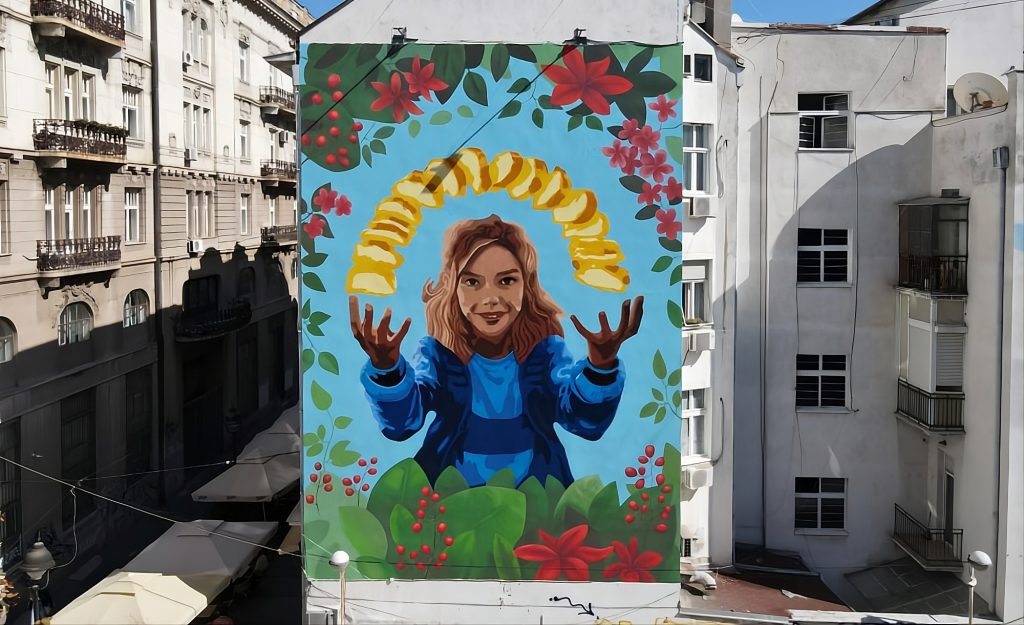 Završen veliki reklamni mural sa ilustracijom devojke, biljaka i čipsa na fasadi u Beogradu