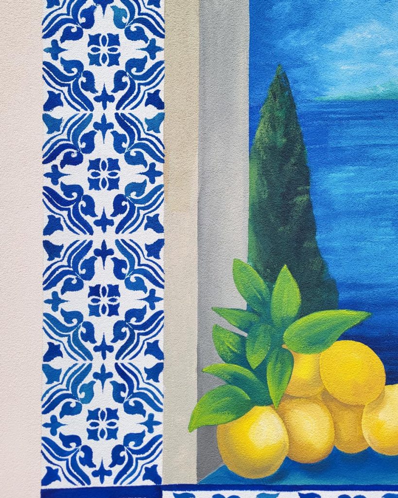 Detalj fasadnog murala sa limunom i plavo-belim mediteranskim ornamentom