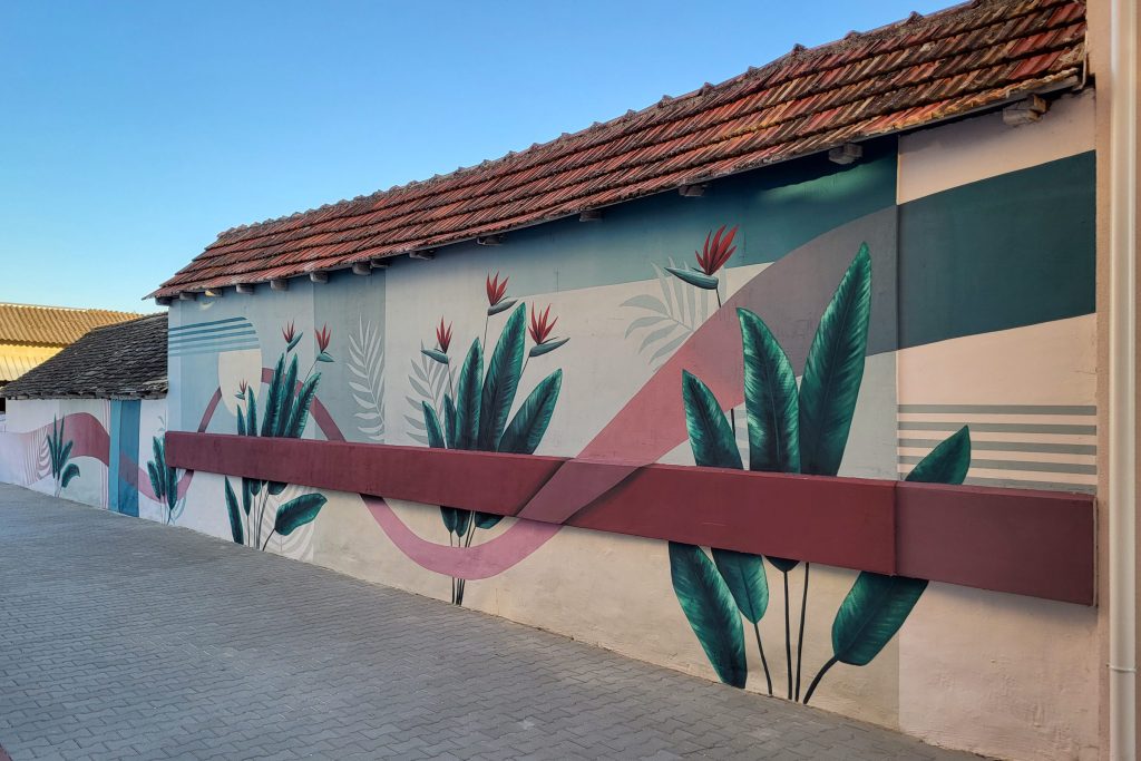 Botanički mural sa geometrijskim elementima na pomoćnom objektu u dvorištu stambene zgrade