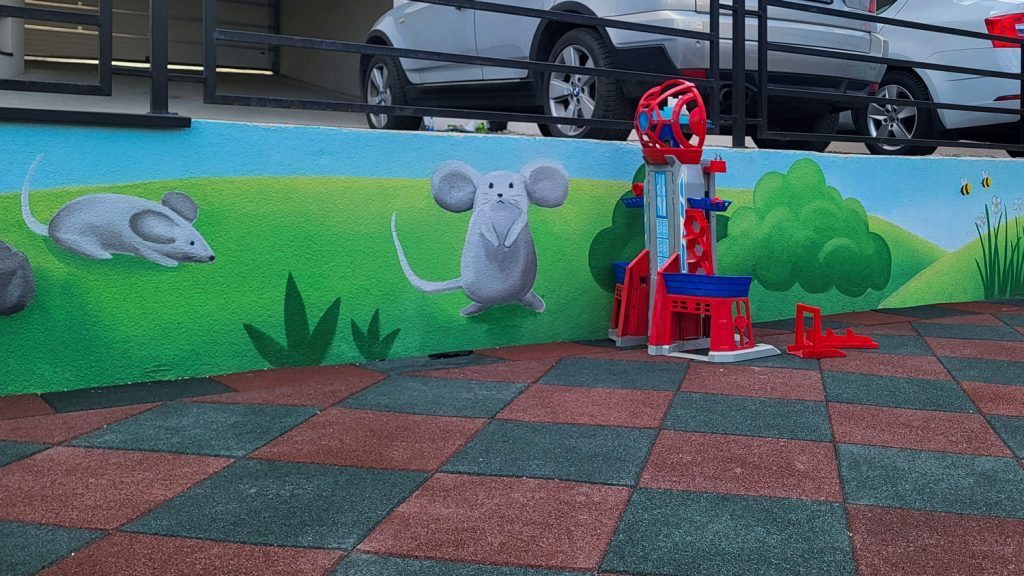 Mural sa miševima i zelenim pejzažom na zidu vrtića